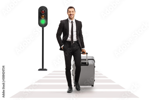 Full length portrait of a businessman with a suitcase crossing street at a pedestrian