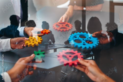Businessteam work together and combine pieces of gears. Partnership and integration concept