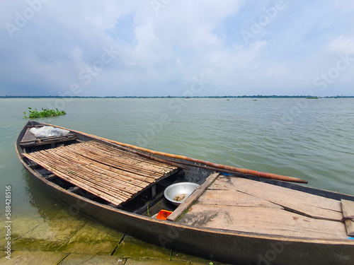 An empty boat on a river bank in Bangladesh with the Meghna River in the Background. Traditional empty boat in south Asia photo