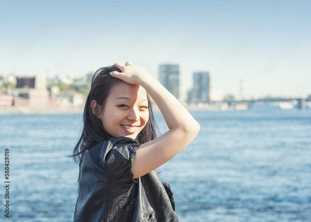 Beautiful young woman with long black hair smiling in the city