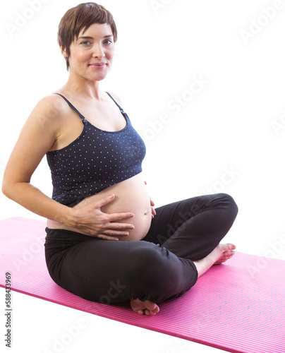 Portrait of pregnent woman sitting on exercise mat