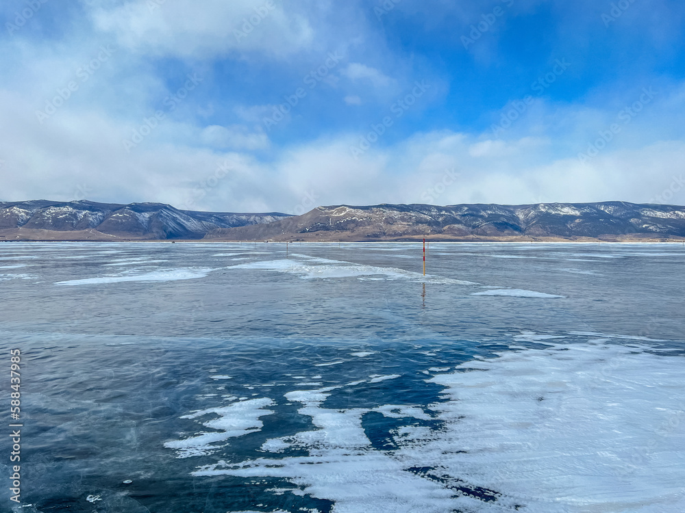 Fototapeta premium pure ice of the frozen lake Baikal against the background of mountains. frozen winter Baikal