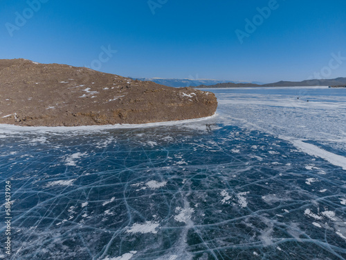 pure ice of the frozen lake Baikal against the background of mountains. frozen winter Baikal