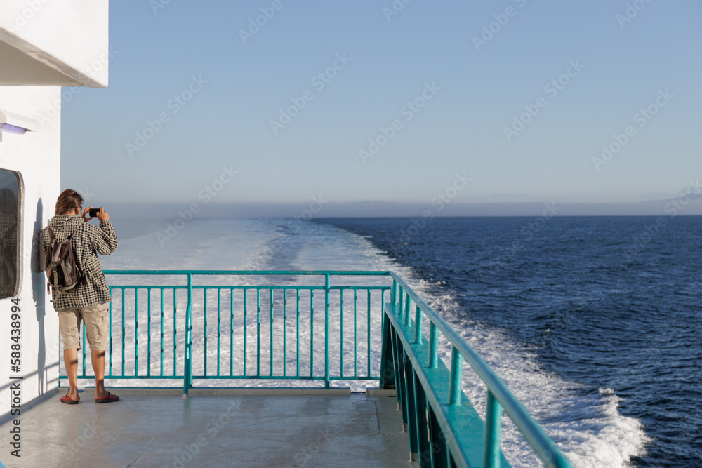 Man looking at the sea from the deck of a ferry