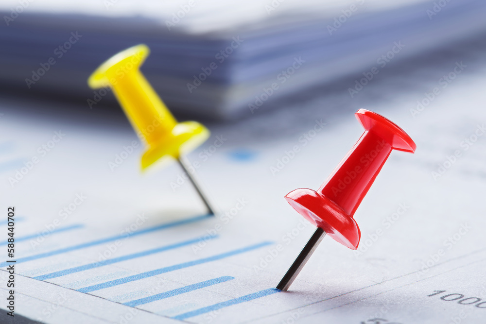 Marking financial chart by pins.Share listing and checking financial chart. Concept of banking, financial report and financial audit. Marking financial chart by pins.Share listing and checking financial chart. Concept of banking, financial report and financial audit.