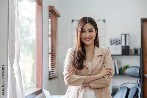 Confident Asian businesswoman standing with her arms crossed. smiling and looking at the camera. Free Download Confident Asian businesswoman standing with her arms crossed. smiling and looking at the camera. - GFXLoad