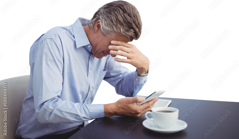 Frustrated businessman using mobile phone while having coffee Frustrated businessman using mobile phone while having coffee