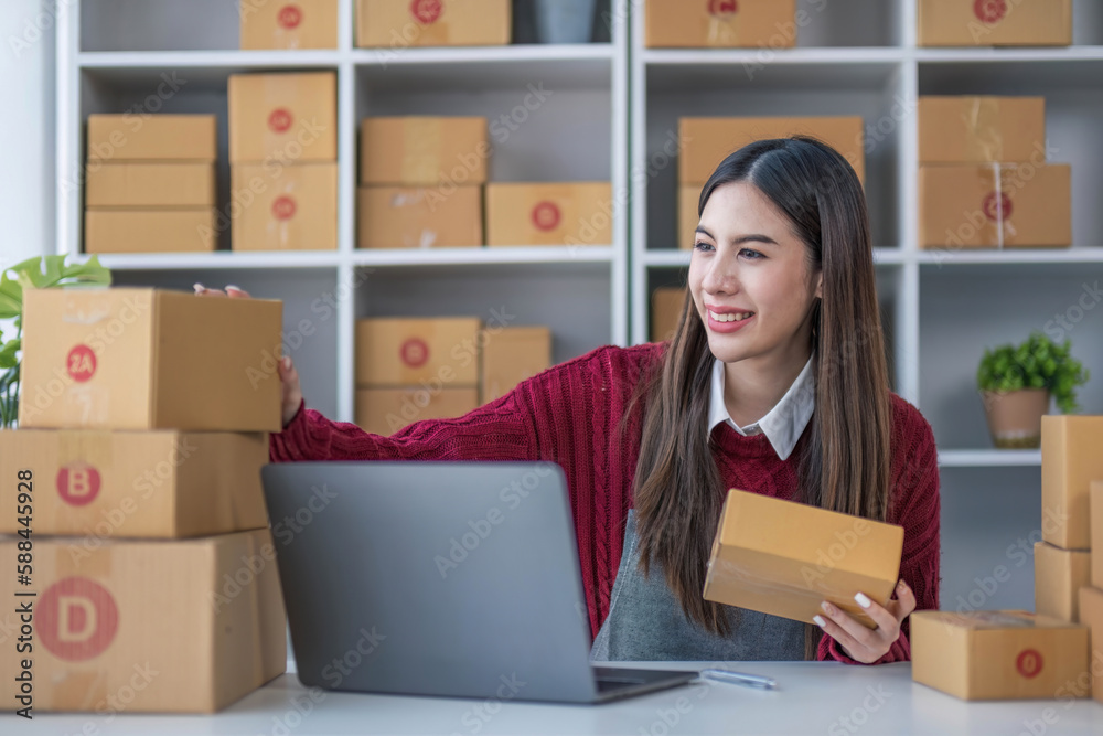Startup small business entrepreneur SME, asian woman packing cloth in box. Portrait young Asian small business owner home office, online sell marketing delivery, SME e-commerce telemarketing concept. Startup small business entrepreneur SME, asian woman packing cloth in box. Portrait young Asian small business owner home office, online sell marketing delivery, SME e-commerce telemarketing concept.