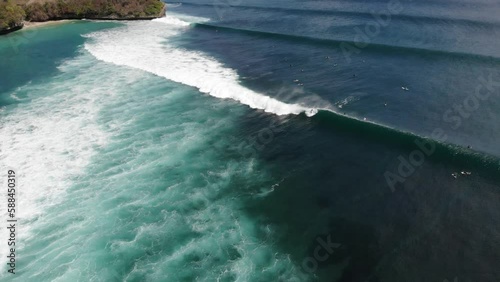 aerial drone view of surfers at beach in Uluwatu Bali