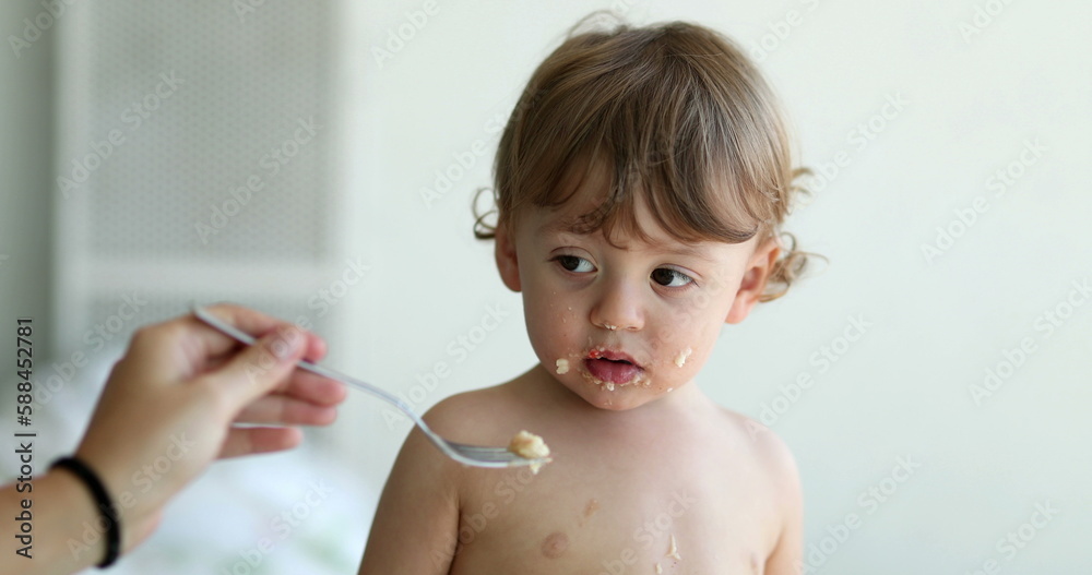 Baby boy refusing food. Child infant not wanting spoon Baby boy refusing food. Child infant not wanting spoon