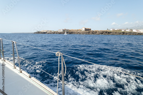 Convés do iate branco navegando em mar aberto chegando a ilha Tenerife photo