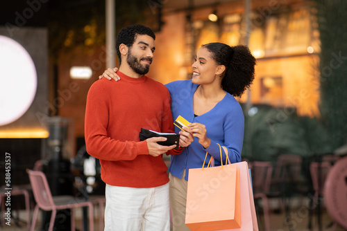 Husband Paying For Shopping Giving Credit Card To Wife Outdoor