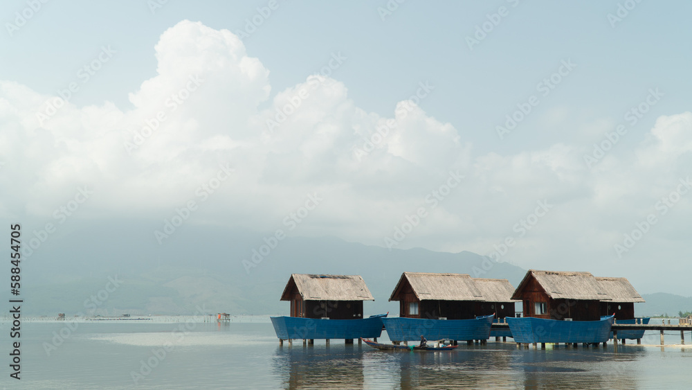 Blue fishing accommodation in the river against the background of the sky and clouds