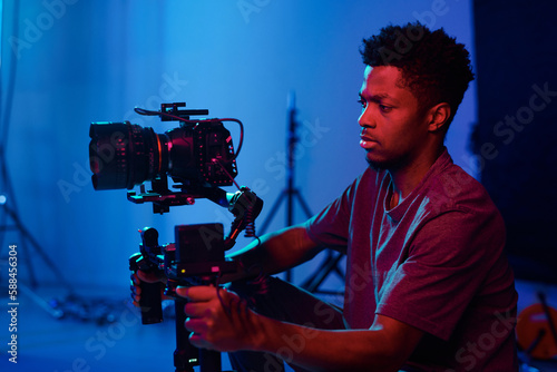 Obraz na plátne African American operator concentrating on his work, he using camera on the set