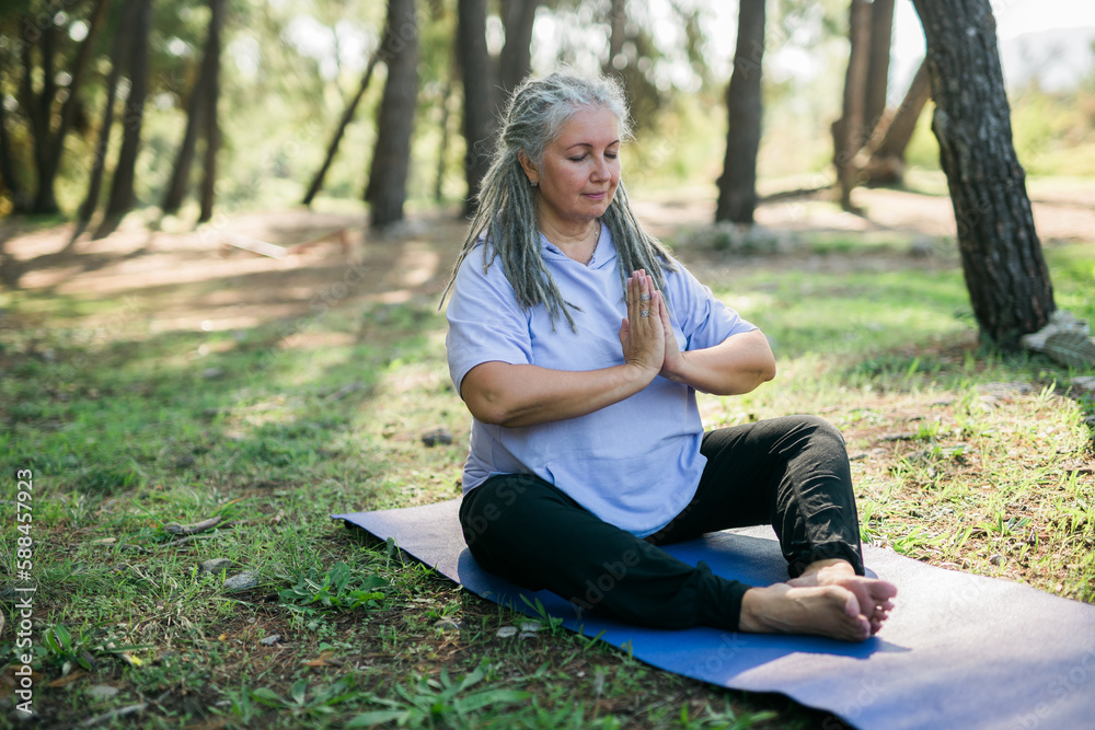 Mindful senior woman portrait with dreadlocks meditating on nature close up copy space - wellness and yoga practice Mindful senior woman portrait with dreadlocks meditating on nature close up copy space - wellness and yoga practice