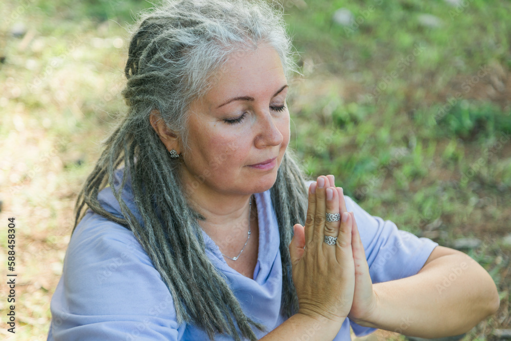 Mindful senior woman portrait with dreadlocks meditating on nature close up - wellness and yoga practice Mindful senior woman portrait with dreadlocks meditating on nature close up - wellness and yoga practice