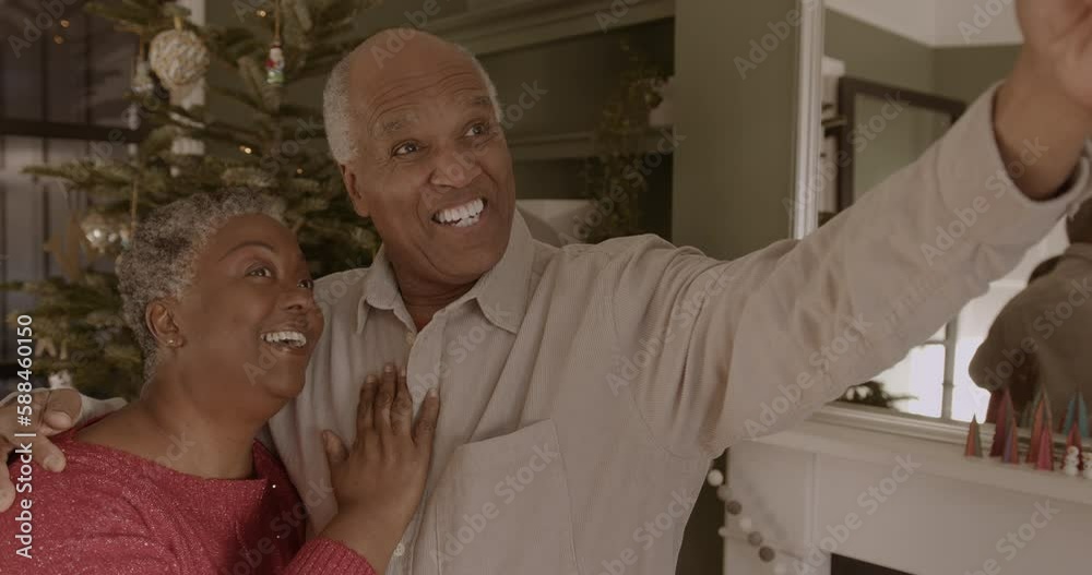 Senior Couple taking Selfie in front of Christmas Tree at home Senior Couple taking Selfie in front of Christmas Tree at home