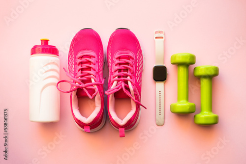 Workout, healthy lifestyle concept. Sneakers, dumbbells, fitness bbracelet and bottle of water. Flat lay image.