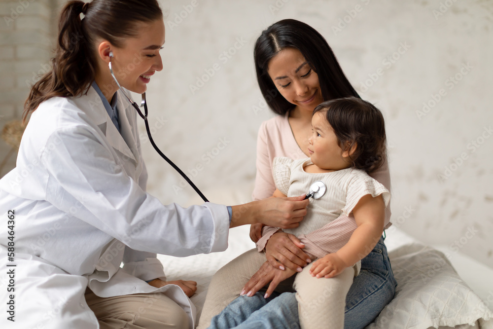 Fototapeta premium Happy Female Doctor Doing Baby Health Checkup In Modern Clinic