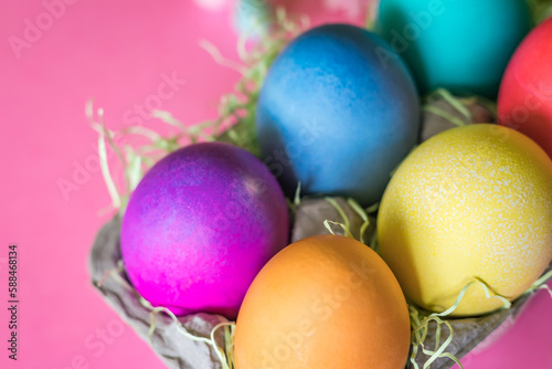 Overhead Angle of Colorful vibrant easter eggs on a pink background
