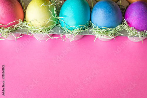 Overhead Angle of Colorful vibrant easter eggs on a pink background