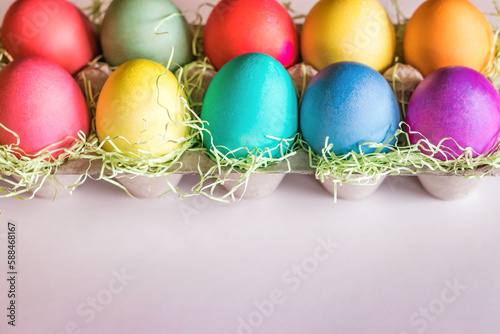 Vibrant colorful easter eggs on a light pink background