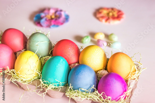 Top Angle Colorful vibrant easter eggs on a light pink background