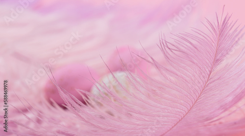 Easter candy chocolate eggs and almond sweets lying on pink feathers background. Happy Easter concept.