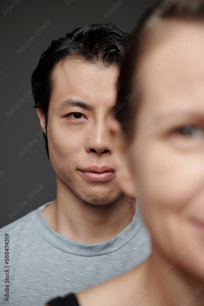 Japanese man standing behind mature woman and looking at camera, society concept Japanese man standing behind mature woman and looking at camera, society concept