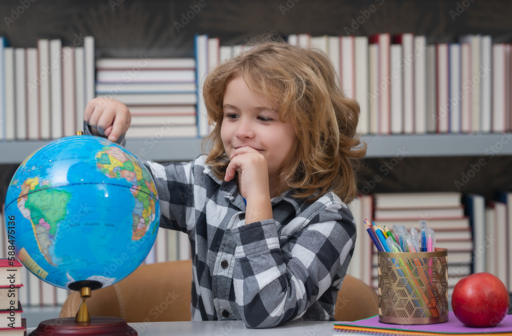 School kid pupil looking at globe in library at the elementary school. World globe. School kid 7-8 years old with book go back to school. Little student. Education concept. School kid pupil looking at globe in library at the elementary school. World globe. School kid 7-8 years old with book go back to school. Little student. Education concept.