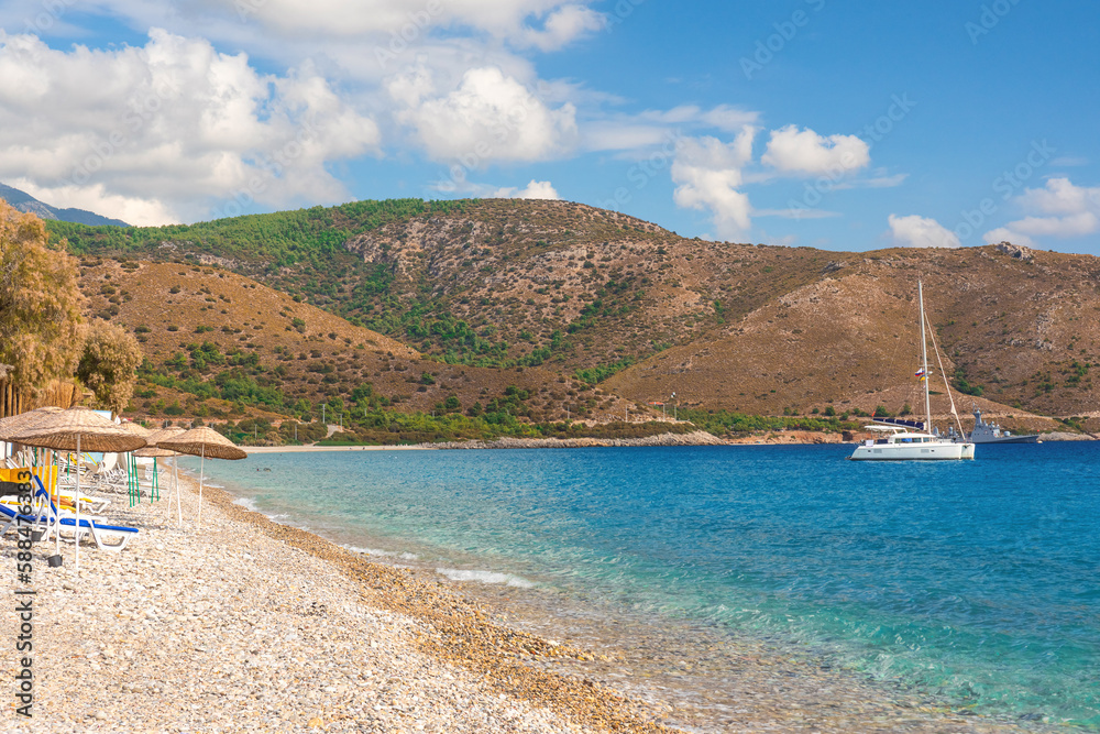 Turkey summer resort with pebble beach and yacht. Palamutbuku beach in Datca Peninsula, Mugla region, Turkey