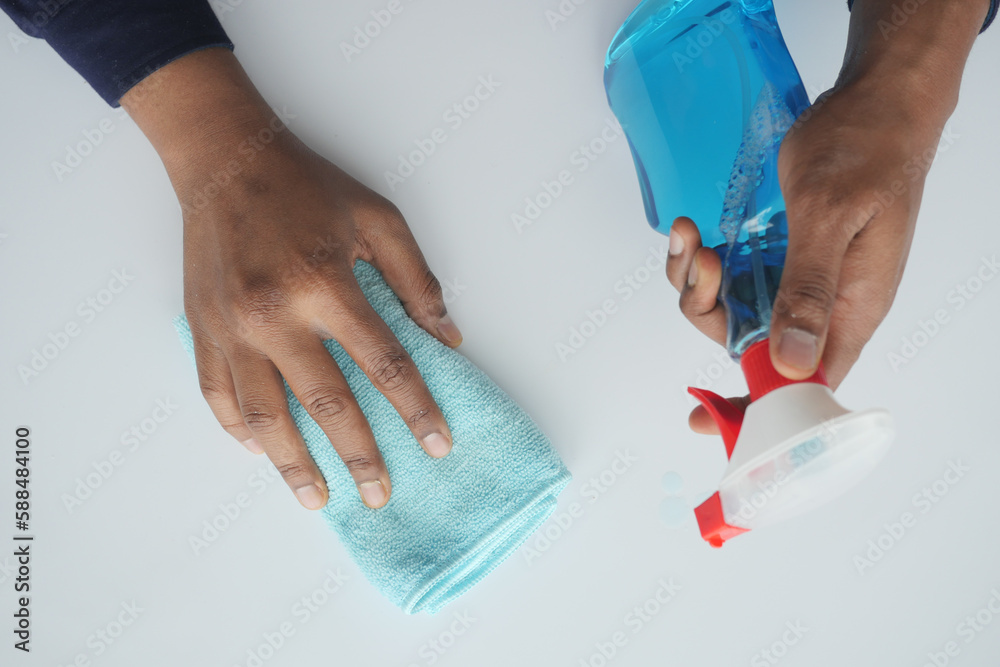 hand in blue rubber gloves holding spray bottle with copy space hand in blue rubber gloves holding spray bottle with copy space