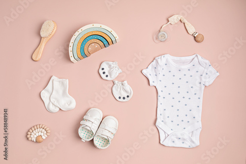 Mockup of  infant bodysuit made of organic cotton with eco friendly baby accessories. Onesie template for brand, logo, advertising. Flat lay, top view photo