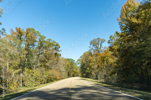 Natchez Trace Parkway a National Park Service scenic road and  old route from Natchez  Mississippi to Cumberland River in Tennessee. No traffic on a road lined with autumn trees and fall foliage. 