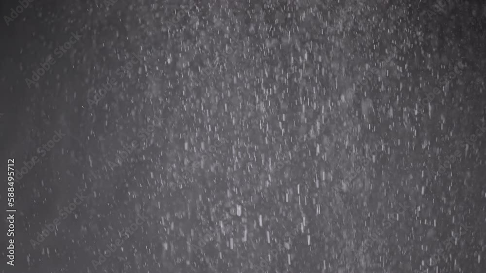 Stream of Falling Confetti, Dust Particles, and Snowfall on Black Background. Blurred abstract dynamic background of flying tinsel, snowflakes, white powder in cloudy mist smoke. Stardust, fireworks. Stream of Falling Confetti, Dust Particles, and Snowfall on Black Background. Blurred abstract dynamic background of flying tinsel, snowflakes, white powder in cloudy mist smoke. Stardust, fireworks.