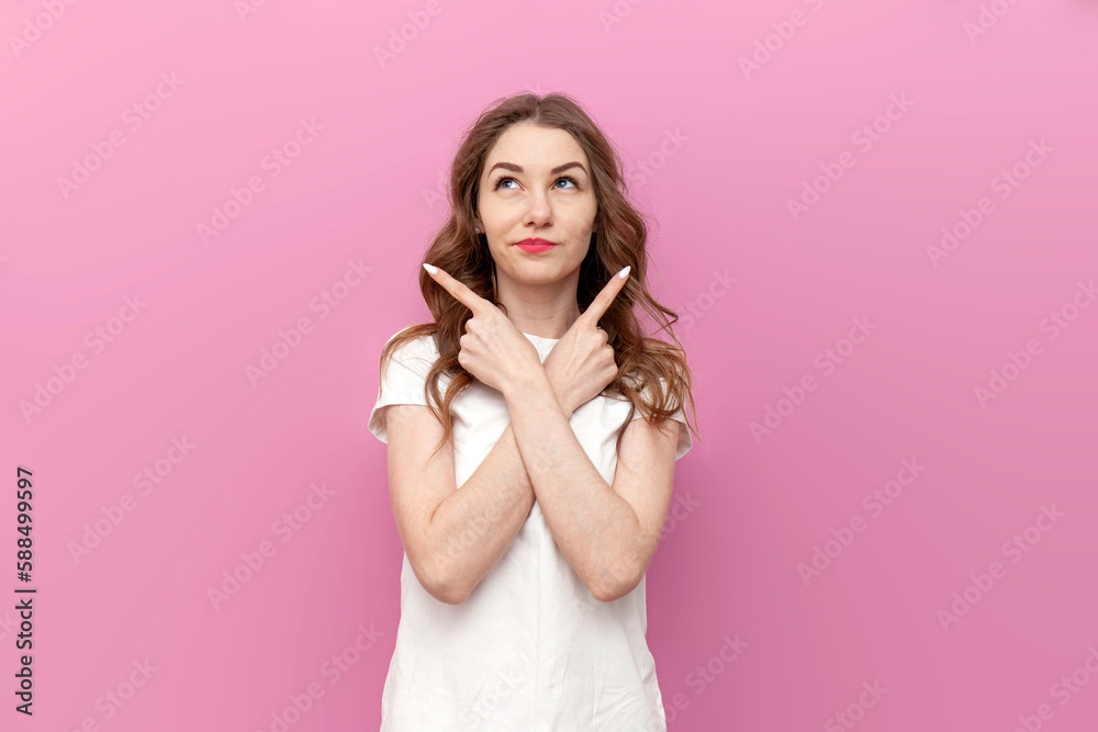 young cute woman chooses from two options and shows with her hands to both sides on pink isolated background young cute woman chooses from two options and shows with her hands to both sides on pink isolated background