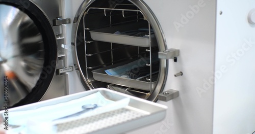 Fotografía The nurse puts the surgical instrument into the autoclave for sterilization