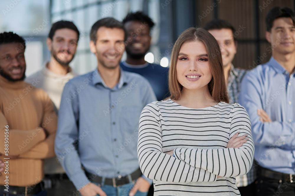 Fototapeta premium Smiling businesswoman looking at camera together with colleagues