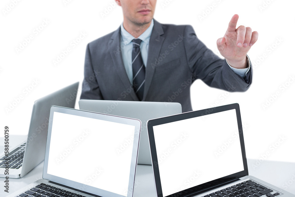 Businessman gesturing while sitting at table with four laptops Businessman gesturing while sitting at table with four laptops