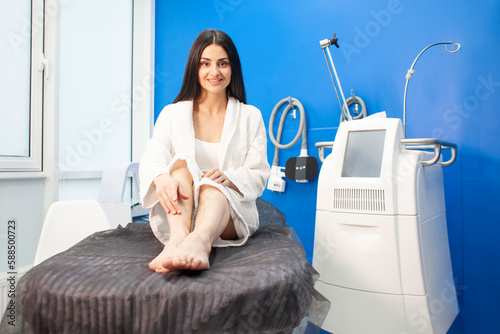 female patient lies on a couch in a cosmetology clinic for a fat removal procedure, coolscalping procedure photo