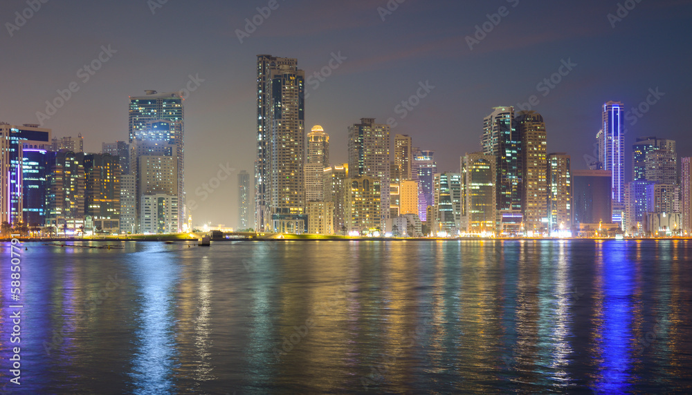 Night landscape of the embankment of the emirate of Sharjah, United Arab Emirates.