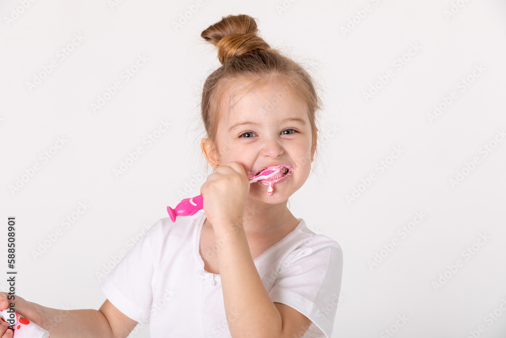 Little cute child girl brushing her teeth on white background. Space for text. Healthy teeth. Little cute child girl brushing her teeth on white background. Space for text. Healthy teeth.