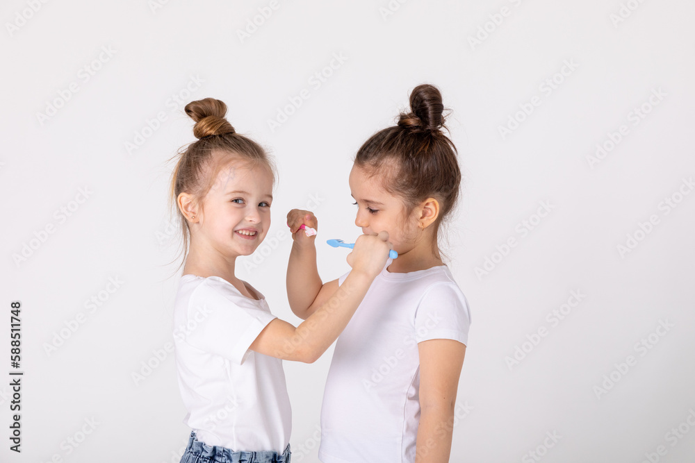 Adorable little girls with tooth brushes. Fun home play. Children smile. Healthy lifestyle, not afraid of dentist. Health care, dental hygiene Adorable little girls with tooth brushes. Fun home play. Children smile. Healthy lifestyle, not afraid of dentist. Health care, dental hygiene