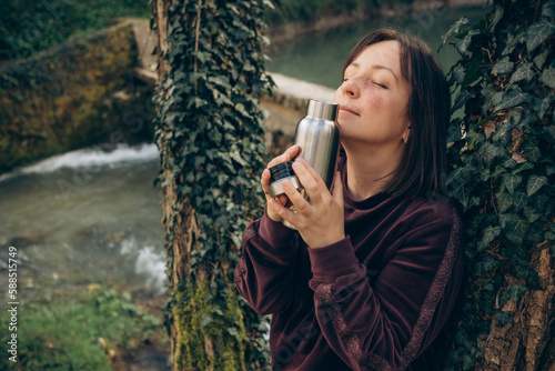  portrait of a girl with a thermos enjoying nature