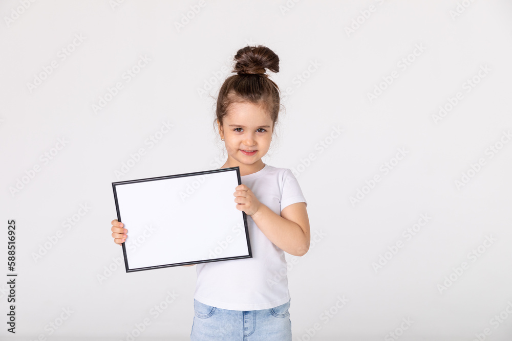 portrait of baby girl holding white drawing Board on white background, young girl is holding a drawing board in her hands. white isolated background portrait of baby girl holding white drawing Board on white background, young girl is holding a drawing board in her hands. white isolated background
