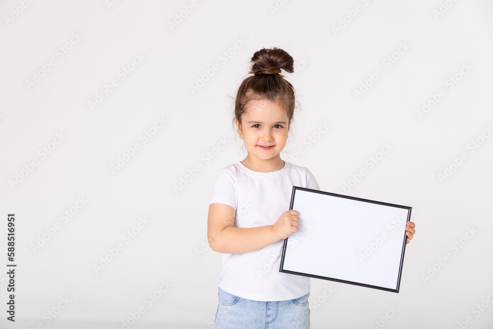 portrait of baby girl holding white drawing Board on white background, young girl is holding a drawing board in her hands. white isolated background portrait of baby girl holding white drawing Board on white background, young girl is holding a drawing board in her hands. white isolated background