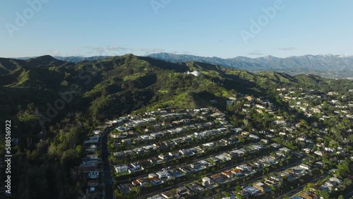 Drone aerial shot moving down on nice house with pool in Hollywood hills, Los Feliz area in Los Angeles, California. Scenic aerial shot expensive houses on green streets at Griffith Observatory park
