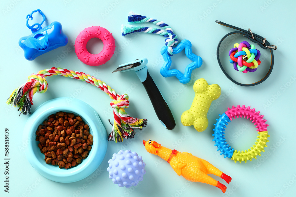 Pet toys and food on blue background. Dog toys, grooming supplies, accessories. Top view. Flat lay.