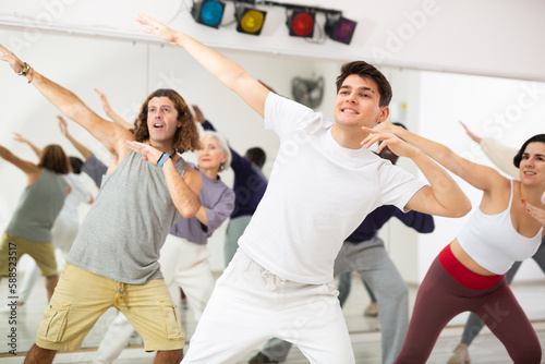Happy caucasian man learning new modern dance in group dance lesson