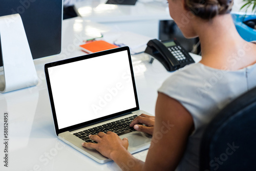 Woman working on laptop while sitting on chair